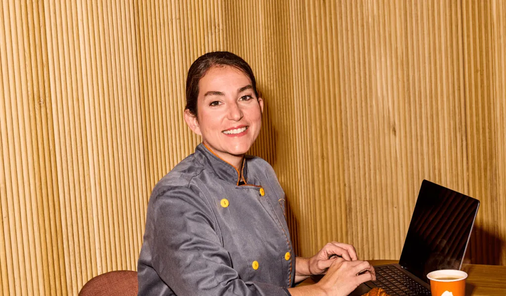 Women on her laptop smiling at the camera