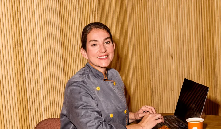 Women on her laptop smiling at the camera